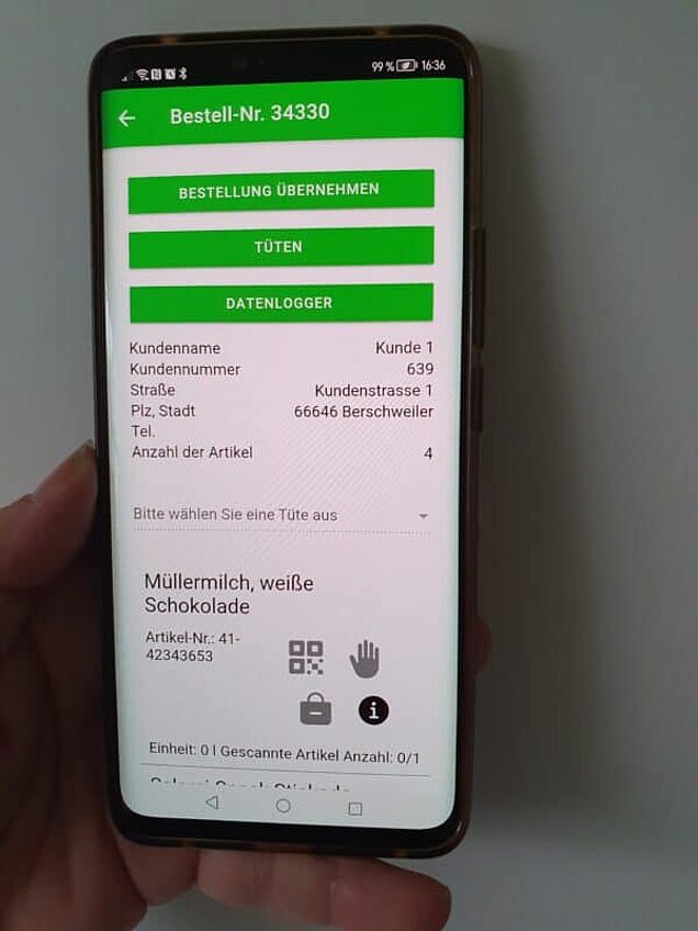 Smartphone mit einer Bestellübersicht in einer App, angezeigt wird Bestellnummer 34330 mit Kundendaten, vier Artikeln und der Position „Müllermilch, weiße Schokolade“ zur Auswahl und Bearbeitung.